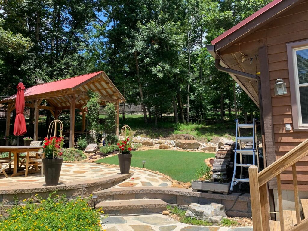 Backyard walkway leading to a red-roof pavilion and landscaped outdoor living area in the CSRA.